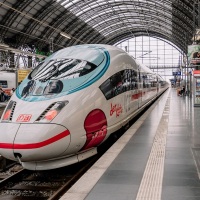 Ein ICE Zug beklebt mit Motiven Comicfigur "der kleine ICE" fährt in den Bahnhof ein
