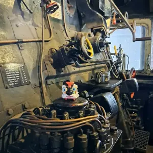Spielfigur Opa Adler steht in einer historischen Steuerzentrale.