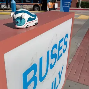 Figur Benni IC Bus steht auf einem Schild mit der Aufschrift "Buses only" (deutsch: "Nur Busse")