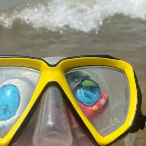 Figuren der kleine ICE und Sally S-Bahn stehen am Meer in einer Traucherbrille.
