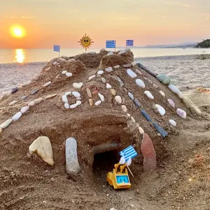 Figur Simsala SUM fährt bei Sonnenuntergang aus einer muschelverzierten Sandburg