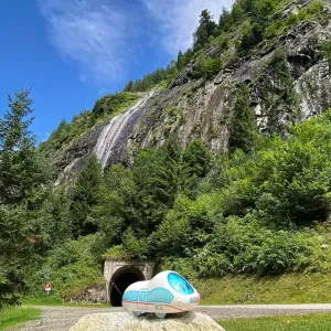 Figur der kleine ICE steht vor einem Gebirgstunnel.