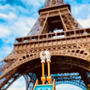 Figur Simsala SUM steht am Fuß des Eiffelturms in Paris.