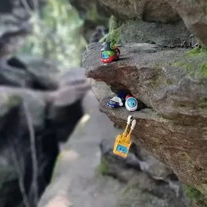 4 Spielfiguren stehen auf Steinen im Gebirge