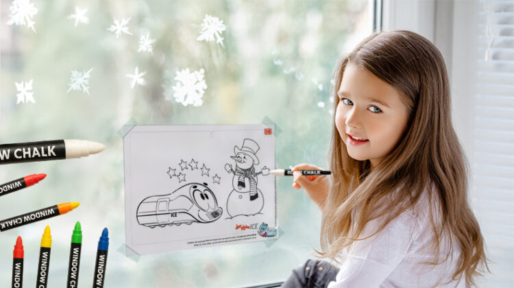 Ein Mädchen malt ein Bild am Fenster aus.