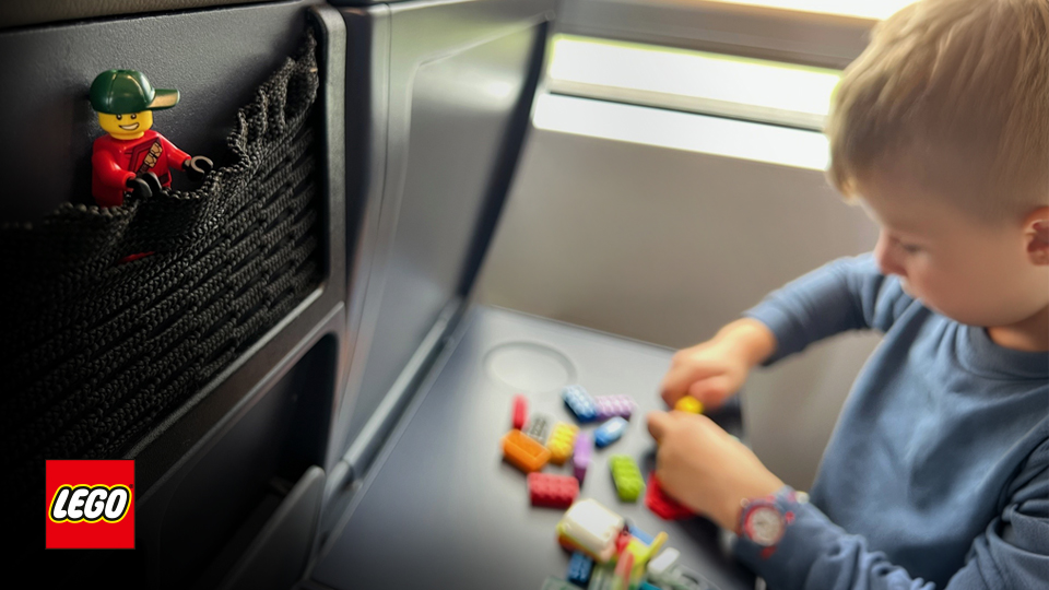 Kind spielen Lego im Zug.