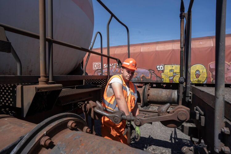 Entkuppler bei der Arbeit zwischen zwei Eisenbahnwagen