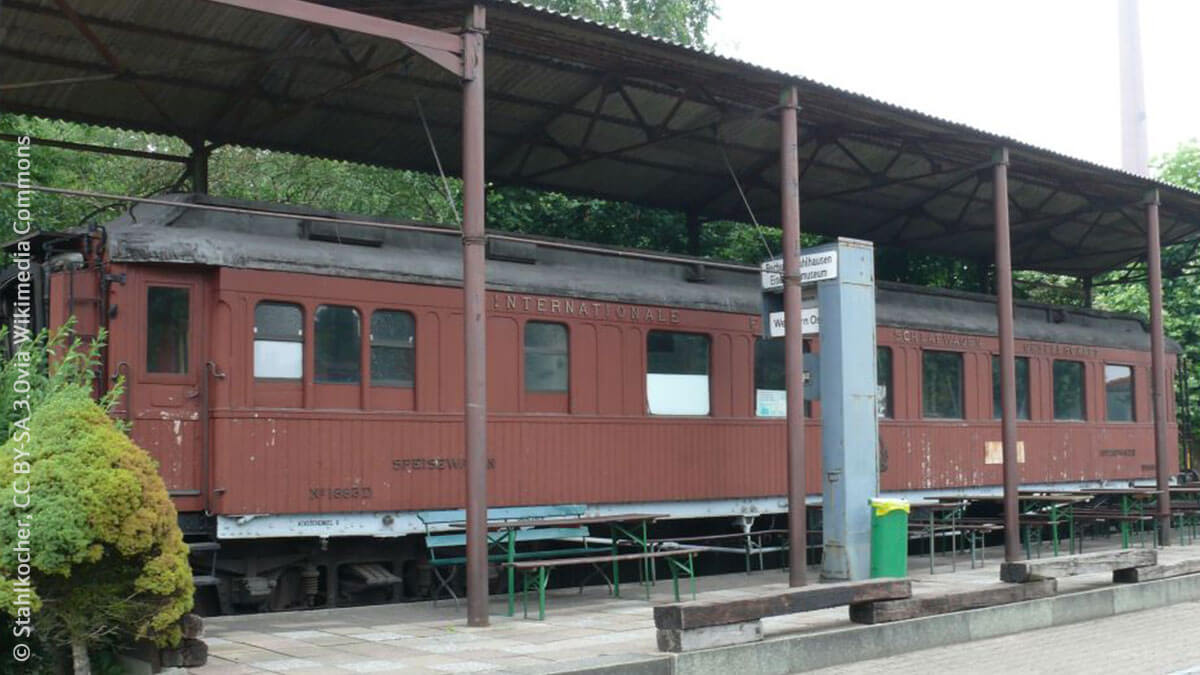 Ein historischer brauner Zugwagen mit Speise- und Schlafwagen steht auf einem nachgebauten Museumsbahnsteig.