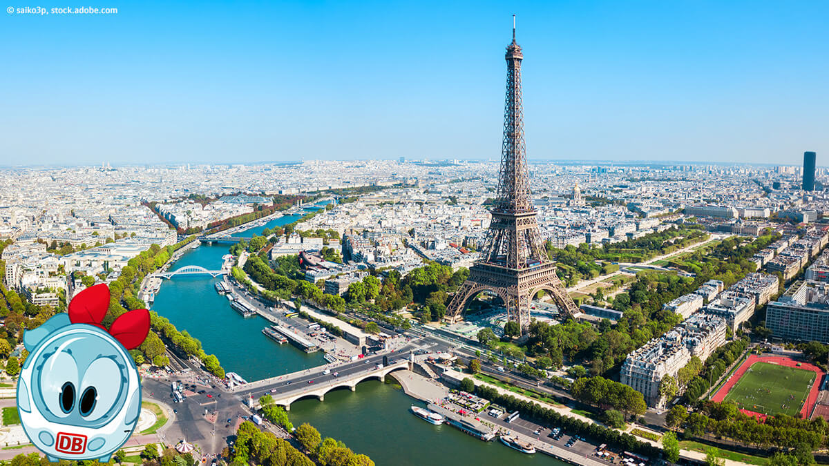 Ida ist in Paris. Der Eiffelturm und die Pariser Straßen und Gebäude sind aus der Vogelperspektive zu sehen.