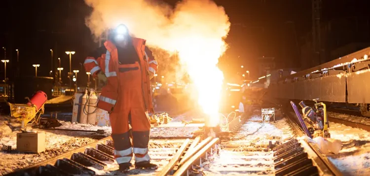 Heller Feuerschein beim Schweißen neuer Gleise bei Nacht