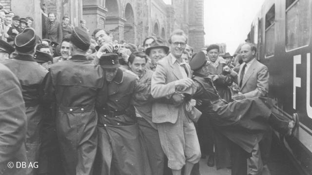 Eine große Gruppe von Leuten umringt einen historischen Weltmeisterzug
