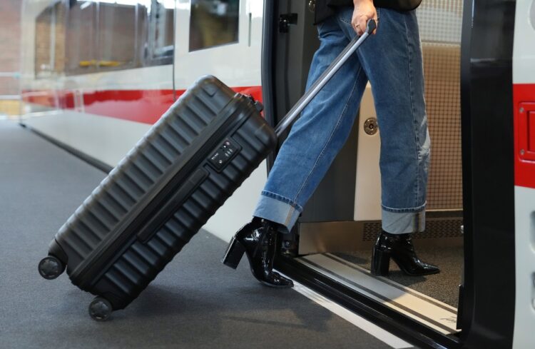Eine reisende Frau mit Koffer steigt über den "Niederflur-Einstieg" in den Zug Eine reisende Frau mit Koffer steigt über den "Niederflur-Einstieg" in den Zug