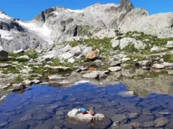 2 Spielfiguren stehen auf einem Stein in einem kleinen Gletscherbach