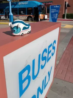 Figur Benni IC Bus steht auf einem Schild mit der Aufschrift "Buses only" (deutsch: "Nur Busse")