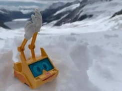 Figur Simsala SUM steht im Gebirge im Schnee
