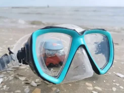 Figur Günni Güterzug schaut am Strand durch eine Taucherbrille.