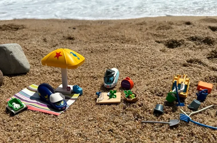 Nick Nachtzug und der kleine ICE stehen am Strand mit Buddelsachen