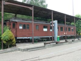 Das Bild zeigt einen historischen Speisewagen der "Compagnie Internationale des Wagons-Lits" (CIWL), der Teil des legendären Orient-Express war. Alter brauner Speisewagen der Compagnie Internationale des Wagons-Lits unter einem Dach.