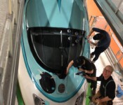 Familien-Aktion: Der kleine ICE ganz groß Techniker bringen in der Werkstatt bunte Motive auf einen ICE-Zug auf.