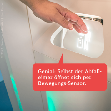 Bild 3 von 4 Hand aktiviert berührungslos den Deckel eines Abfalleimers in einer Zugtoilette.