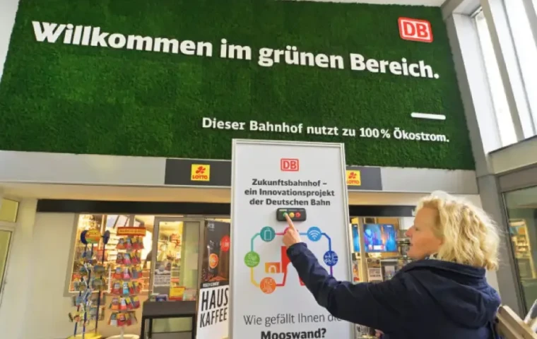 Eine Reisende im grünen Bereich eines ökologischen Bahnhofs