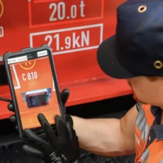 Arbeiter hält Handydisplay in die Kamera