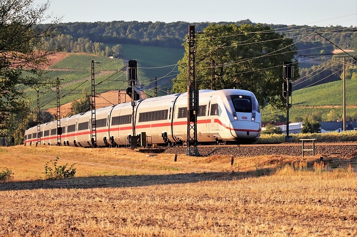 Ein ICE 4 fährt durch eine schöne Landschaft mit vielen Feldern
